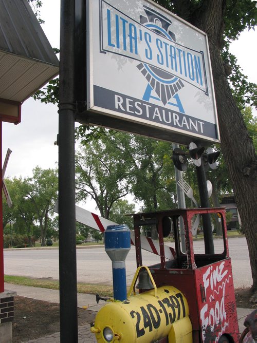 Canstar Community News Aug. 27, 2018 - Lita's Station's sign stands over one of the small train cars that resturant owner Norman Winter made. (ANDREA GEARY/CANSTAR COMMUNITY NEWS)