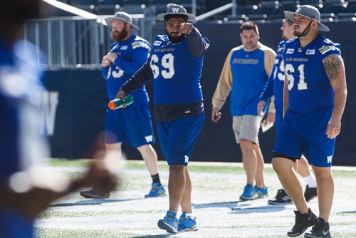 MIKE DEAL / WINNIPEG FREE PRESS
Winnipeg Blue Bombers' Sukh Chungh (69) and the rest of the offensive line walk onto the field for practice at Investors Group Field Friday morning.
180907 - Friday, September 07, 2018.