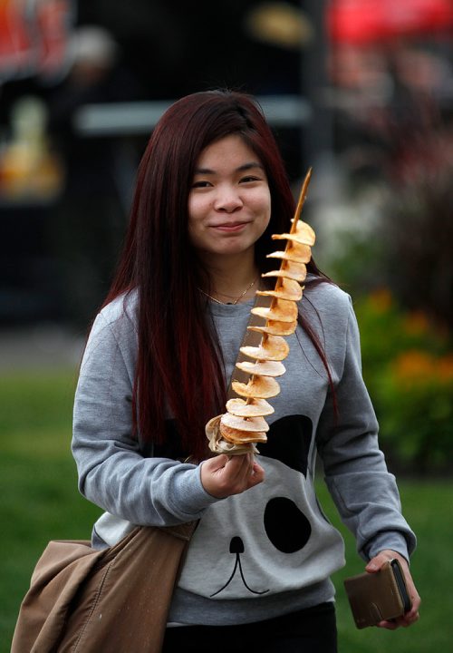 PHIL HOSSACK / WINNIPEG FREE PRESS -  Charolette Chua beams behind her spiral potato  "French Fry on a stick"  at Manyfest Friday evening along Broadway near Memorial. STANDUP - Sept 7, 2018