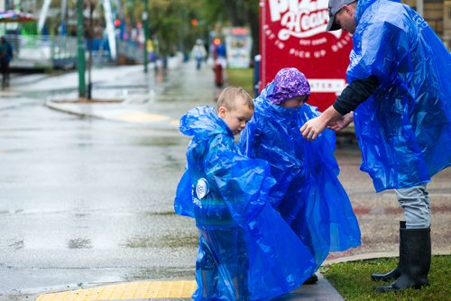 MIKAELA MACKENZIE / WINNIPEG FREE PRESS
Nathan MacKay helps his children, Kellen (left) and Nataleigh, get their rain ponchos on for Manyfest in Winnipeg on Saturday, Sept. 8, 2018. 
Winnipeg Free Press 2018.