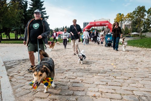 Daniel Crump / Winnipeg Free Press. D'arcy Johnston (left) and his three legged dog, Darnold, lead the seventh annual Woof Walk in support of Darcy's Animal Rescue Centre. September 14, 2018.