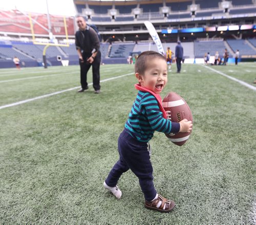 TREVOR HAGAN / WINNIPEG FREE PRESS
Landen Kwong, 14mo, and his father, Wiley, on the field at Fan Fest, Sunday, September 16, 2018.