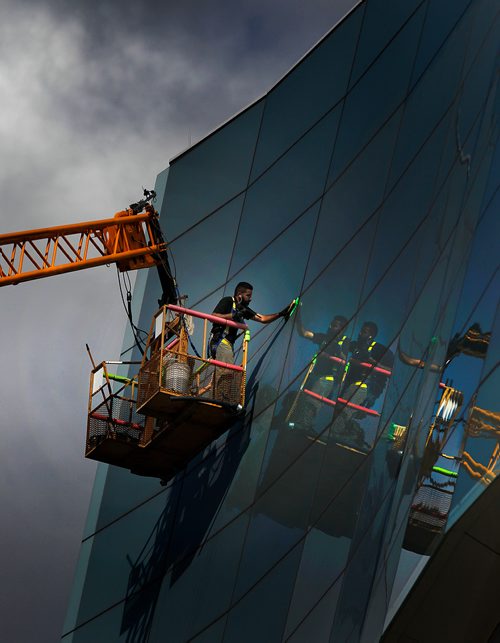 PHIL HOSSACK / WINNIPEG FREE PRESS -  STAND-UP - A window washer in a crane bucket details the windows on the Candian Human Rights Museum Tuesday afternoon.  - Sept 18, 2018