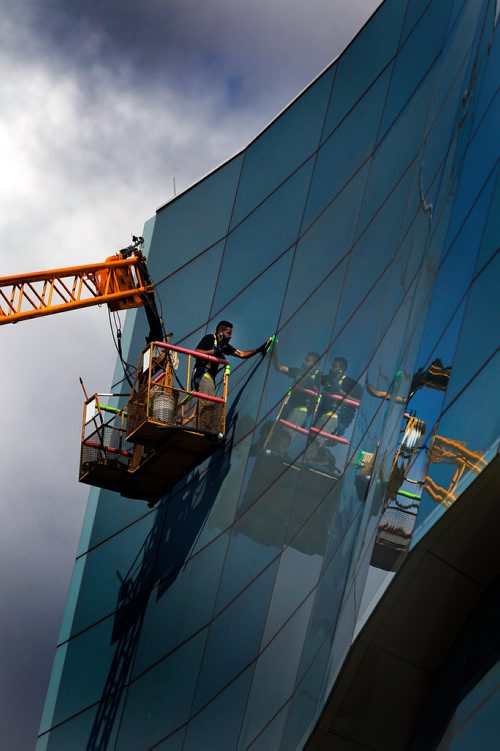 PHIL HOSSACK / WINNIPEG FREE PRESS -  STAND-UP - A window washer in a crane bucket details the windows on the Candian Human Rights Museum Tuesday afternoon.  - Sept 18, 2018