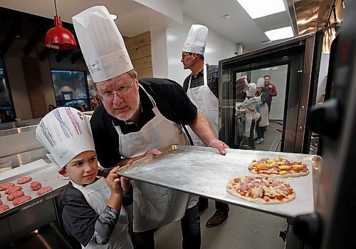 PHIL HOSSACK / WINNIPEG FREE PRESS - Doug Speirs and 8 yr old Jaerden Peters wrangle a pair of pizza's into the oven Monday evening at Capitol Grill on Broadway resteraunt during a Variety Children's CHarity of Manitoba event for about 60 special needs kids and their parents. See release and Doug's story.   - Sept 24, 2018
