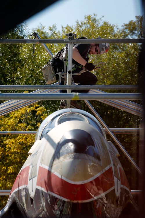 PHIL HOSSACK / WINNIPEG FREE PRESS - A scaffolder clips his safety harness onto the framework surrounding the T33-21232 which has stood on a pedestal at Portage and Woodhaven since 1967. Sitting on the ground now the vintage fighter/trainer is being cleaned up and repainted in it's original operational colours before being reinstalled on the rebuilt pedestal later this winter.  - Sept 25, 2018