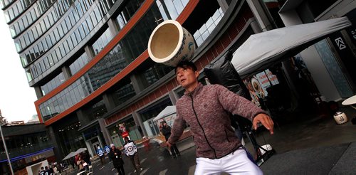 PHIL HOSSACK / WINNIPEG FREE PRESS -  A member of the "Lights of the North" acrobatic team balances a clay pot Thursday evening in the newly opened True North Square.  - Sept 27, 2018