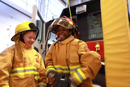 RUTH BONNEVILLE / WINNIPEG FREE PRESS

Standup photo

Grade six students, Sofia Marchenko (left) and Fifehanmi Abraham-Ajayi, along with their classmates from Hedge Middle School, try on  gear worn by firefighters in the field at Number 11 Fire Station Thursday.  The outing was in honour of the International Day of the Girl which was being recognized by the Winnipeg Fire Paramedic Service (WFPS) partnered with the Government of Manitobas Status of Women which hosted groups of Winnipeg girls at four WFPS locations in Winnipeg.  The purpose of these visits was to ensure young girls know that careers in the Fire and Paramedic Service are within their grasp.


More Info below: 
Approximately 100 sixth grade girls from four Winnipeg schools had the opportunity to participate in WFPS station tours, ask questions to female responders and try their hand at a variety of drills and demonstrations, including learning about CPR, trying on firefighter turn out gear and learning stretcher and hose handling skills.

Today is International Day of the Girl, and this years theme centres around preparing girls for the workforce, said Manitoba Sustainable Development Minister Rochelle Squires, minister responsible for the status of women. This event reminds us that no career goal is off limits for girls, including the Winnipeg Fire and Paramedic Service. I hope the girls participating today have fun, make new friends and come away with greater confidence in their abilities.

Currently, within the WFPS firefighting ranks, approximately five per cent of staff identify as female. Within EMS, that number jumps to approximately 35 per cent. Research states that many young people start leaning towards their particular career interests by approximately 12 years old, which is why todays event is aimed at girls of this age.

Standup photo 

October 11, 2018