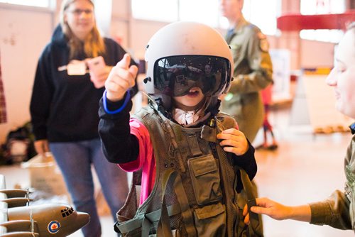 MIKAELA MACKENZIE / WINNIPEG FREE PRESS
Racheal Flynn points to an airplane while trying on gear on aviation day at the Royal Aviation Museum of Western Canada in Winnipeg on Saturday, Oct. 13, 2018. 
Winnipeg Free Press 2018.