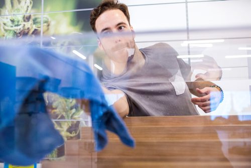 MIKAELA MACKENZIE / WINNIPEG FREE PRESS
Nathan McMullin cleans the sensory bar display case as Delta 9 cannabis store prepares for opening day in Winnipeg on Tuesday, Oct. 16, 2018. 
Winnipeg Free Press 2018.