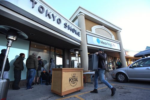 MIKE DEAL / WINNIPEG FREE PRESS
Dom Druwe co-manager with Cafe Postal sets up a portable cafe in front of Tokyo Smoke offering free coffee for patrons while they wait for the store to open. 
About a couple dozen people stand outside Tokyo Smoke waiting for a chance to be some of the first in Winnipeg to be able to purchase recreational cannabis legally now that the laws have been changed. 
181017 - Wednesday, October 17, 2018.