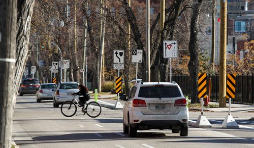 MIKE DEAL / WINNIPEG FREE PRESS
A cyclist crosses McDermot Avenue Friday afternoon. 
181019 - Friday, October 19, 2018.