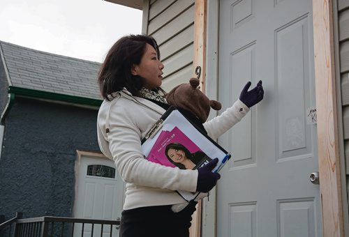 Canstar Community News Oct. 16 - Winnipeg School Division trustee candidate Yijie Chen holds her two-month old Sophia Jacks while door-knocking in the West End. (EVA WASNEY/CANSTAR COMMUNITY NEWS/METRO)