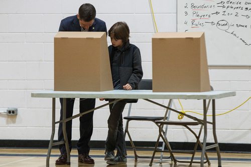 MIKE DEAL / WINNIPEG FREE PRESS
Brian and Tracy Bowman bring their kids Hayden (black jacket), 10, and Austin (grey jacket), 8, to the voting booth at École Charleswood School Wednesday morning to vote in the civic election.
181024 - Wednesday, October 24, 2018.