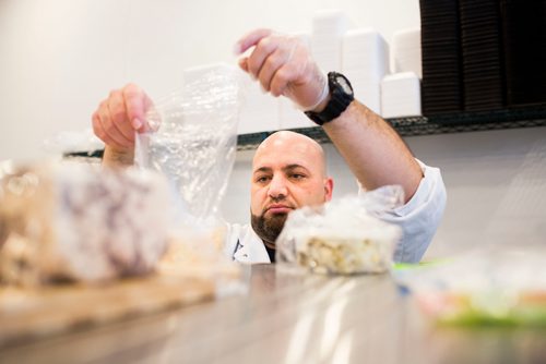 MIKAELA MACKENZIE / WINNIPEG FREE PRESS
Murhaf Abdul Karim packages cheeses for a customer as Blady Middle Eastern market opens in Winnipeg on Friday, Oct. 26, 2018. 
Winnipeg Free Press 2018.