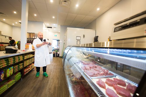 MIKAELA MACKENZIE / WINNIPEG FREE PRESS
Murhaf Abdul Karim takes pictures of the display case as Blady Middle Eastern market opens in Winnipeg on Friday, Oct. 26, 2018. 
Winnipeg Free Press 2018.