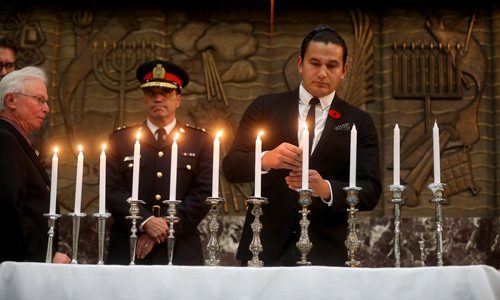 TREVOR HAGAN / WINNIPEG FREE PRESS
Wab Kinew lights one of 11 candles in memory of the victims of the 11 people murdered at the Tree of Life Synagogue in Pittsburgh on Saturday during a vigil at the Shaarey Zedek Synagogue, Tuesday, October 30, 2018.