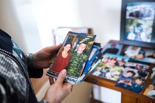 MIKAELA MACKENZIE / WINNIPEG FREE PRESS
Anita Cenerini, who fought for her son to receive full military honours after his suicide and is the 2018 National Silver Cross Mother, looks at a photo of her son before being deployed in her home in Winnipeg on Thursday, Nov. 1, 2018. 
Winnipeg Free Press 2018.