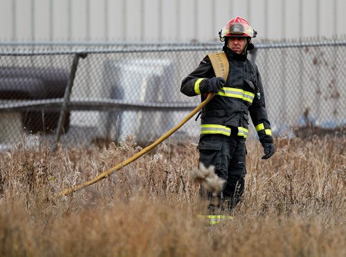 PHIL HOSSACK / WINNIPEG FREE PRESS - A city firefighter moves hose into position fighting a fire at an oil seed crushing plant on (Google Earth lists the building as Friendly Family Farms) Dawson Road Monday afternoon. - November 05, 2018