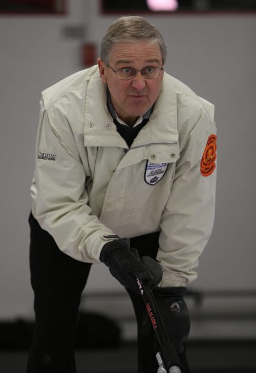Brandon Sun 13032009 Skip Doug Armour guides in a rock during his rink's match against Barry Sadler's rink during the Manitoba Master's Men's Curling Championships at the Minnedosa Curling Club on Friday afternoon. (Tim Smith/Brandon Sun)