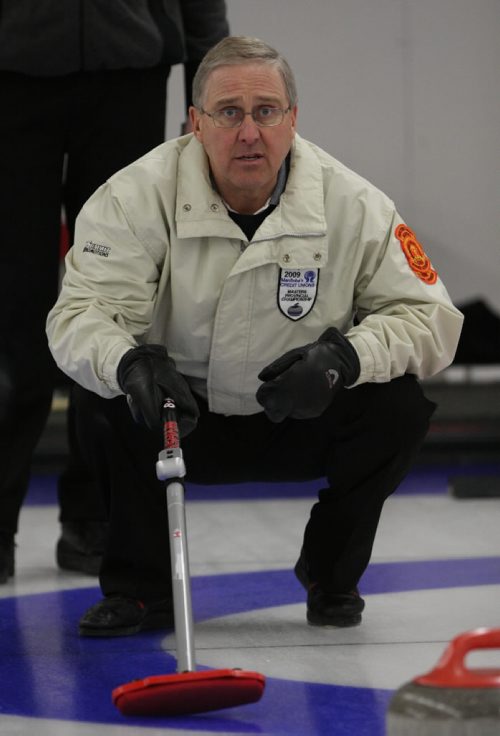 Brandon Sun 13032009 Skip Doug Armour guides in a rock during his rink's match against Barry Sadler's rink during the Manitoba Master's Men's Curling Championships at the Minnedosa Curling Club on Friday afternoon. (Tim Smith/Brandon Sun)