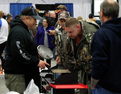 PHIL HOSSACK / WINNIPEG FREE PRESS - Garther Cheung (aka Big China Outdoors) lets a pair of fishers sniff his Thai Green Curry Saturday afternoon, Everything from folding fishing shacks to Thai Green Curry Walleye was up for grabs at the first ever Ice Fishing Show Saturday at Red River Exhibition Place. The show continues on through Sunday. - November 17, 2018