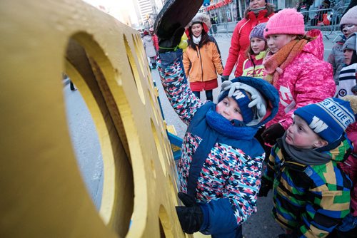 Daniel Crump / Winnipeg Free Press. Hustyn McNabb plays an oversized version of the game Connect Four with other kids at the Santa Claus Parade street party. November 17, 2018.