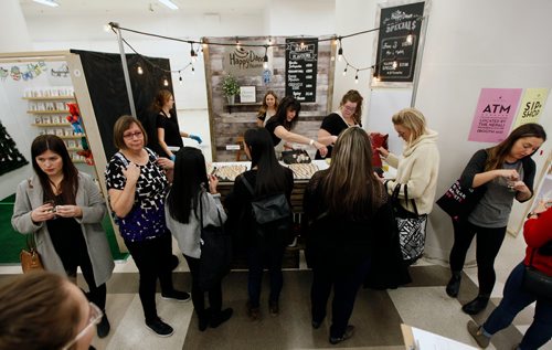 PHIL HOSSACK / WINNIPEG FREE PRESS - Let the shopping begin, crowds swarmed Third and Bird's annual Christmas Market Friday evening in The Bay's basement. Customers file past Happy Dance Hummis to collect samples before buying in. - November 23, 2018