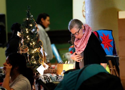 PHIL HOSSACK / WINNIPEG FREE PRESS - Star Blankets to slippers, everything was on the table Saturday at 8th annual Indigenous Arts & Craft Show at the Neeginan Centre (181 Higgins Ave.) Shelly Girardin checks out the goods on a break from working sales at another table.   - November 24, 2018