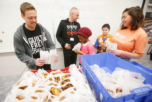 JOHN WOODS / WINNIPEG FREE PRESS
Scott Reimer, right, and Marc Priestley, co-owners of Nuburger, hand out their Crispy Potato Thins with Chantal Lacoste, Mealshare Winnipeg Community Leader to kids at a Boys and Girls Club event at Dalhousie School Tuesday, November 27, 2018. In the Boys and Girls Club's Mealshare program partnering local restaurants provide funds from their selected Mealshare menu items to local charities to provide meals to youth in need.