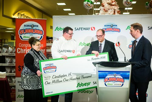 MIKAELA MACKENZIE / WINNIPEG FREE PRESS
Gord Miller, TSN sportscaster (right), and Scott Chollak, VP of retail operations, present the Safeway $1,000,000 Score & Win contest to Christopher Haley and his wife, Karen, at Safeway in Winnipeg on Wednesday, Nov. 28, 2018.
Winnipeg Free Press 2018.