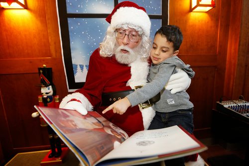 JOHN WOODS / WINNIPEG FREE PRESS
Santa, played by Ron Robinson, reads to Nicholas Cambell, 4, at McNally Robinson Bookstore Sunday, December 2, 2018.