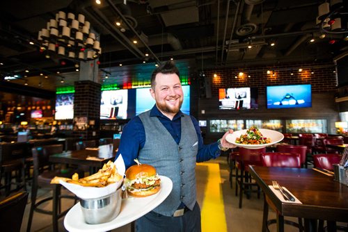 MIKAELA MACKENZIE / WINNIPEG FREE PRESS
Justin Guest, manager, poses with the Nashville Chicken Sandwich and the Dragon Bowl at Brown's Social House downtown location on Monday, Dec. 3, 2018.
Winnipeg Free Press 2018.