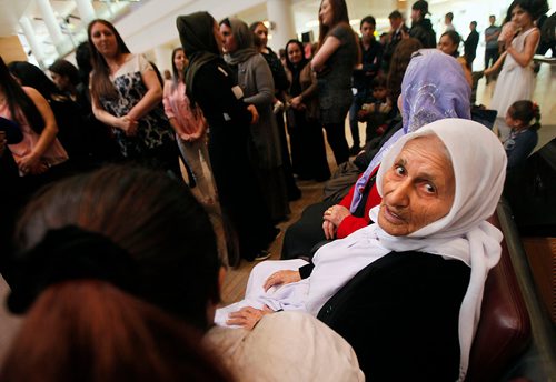 PHIL HOSSACK / WINNIPEG FREE PRESS - Overwhelmed by travel and welcome, Family matriarch Shireen Khudida (centre left) had to take a seat in the midst of the throngs of Yazidi's who came to Richardson International Airport Thursday to welcome the matriarch and the last of "Operation Ezra's" Yazidi families to Winnipeg and Canada. See Carol Sanders story. - March 29, 2018
