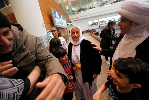 PHIL HOSSACK / WINNIPEG FREE PRESS - Overwhelmed by travel and welcome, Family matriarch Shireen Khudida gazes at a stranger's camera in the throngs of Yazidi's who came to Richardson International Airport Thursday to welcome the matriarch and the last of "Operation Ezra's" Yazidi families to Winnipeg and Canada. Her daughter Base Qave right. See Caorl Sanders story. - March 29, 2018