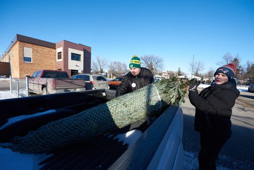 DAVID LIPNOWSKI / WINNIPEG FREE PRESS

Miles Macdonell Collegiate Buckeyes Receiver Miciah Stone (left) and Offensive Lineman Matthew Stow (right), help carry and load Christmas trees for customers at the non-profit volunteer operated Tree Lot at 454 Kimberly Avenue beside Miles Macdonell Collegiate Saturday December 8, 2018.