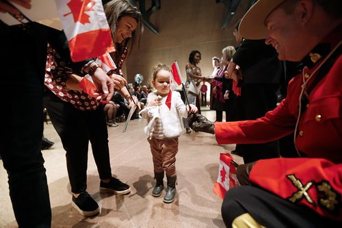 JOHN WOODS / WINNIPEG FREE PRESS
Diane Ainouche receives a flag from a RCMP officer as her mother Laura looks on during a Canadian citizenship ceremony at the Canadian Museum for Human Rights as part of the celebration of the 70th anniversary of the United Nations' Universal Declaration of Human Rights Sunday, December 9, 2018.