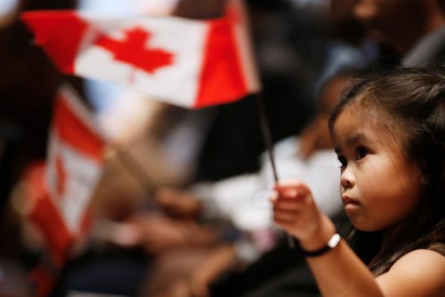 JOHN WOODS / WINNIPEG FREE PRESS
A young girl waves her flag during a Canadian citizenship ceremony at the Canadian Museum for Human Rights as part of the celebration of the 70th anniversary of the United Nations' Universal Declaration of Human Rights Sunday, December 9, 2018.