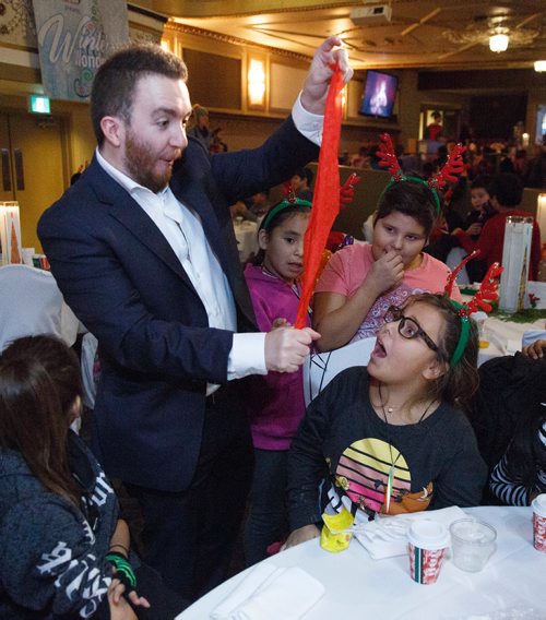 MIKE DEAL / WINNIPEG FREE PRESS
Magician Evan Morgan entertains a table of kids during the Variety Manitoba Winter Wonderland party. Around 300 underprivileged inner city kids were invited to Variety Manitoba's Winter Wonderland childrens party at The Metropoitan Entertainment Centre Monday, December 10. They were served lunch, got to listen to live Christmas music, entertained by magician's, and met Santa and Mrs. Claus. 

181210 - Monday, December 10, 2018.