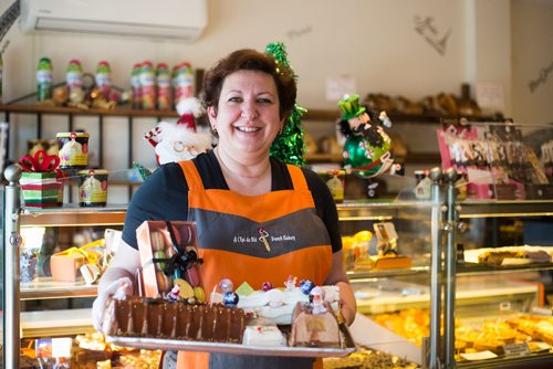 MIKAELA MACKENZIE / WINNIPEG FREE PRESS
Nathalie Gautier holds up a tray of Buches de Noel, buchettes, and macarons at l'Epi de Ble, her French Bakery, in Winnipeg on Thursday, Dec. 13, 2018. 
Winnipeg Free Press 2018.