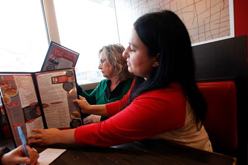 PHIL HOSSACK / WINNIPEG FREE PRESS - Red Top Restaurant owners Vicky Scouras and her daughter Elena exchange emotional looks while sharing the restaurant's history on the menu with the Free Press. Alex Paul's story. December 21, 2018.