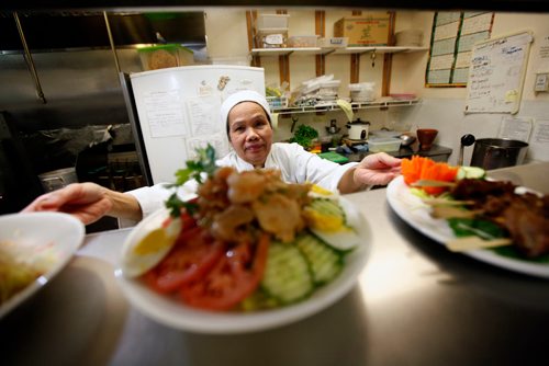 PHIL HOSSACK / WINNIPEG FREE PRESS -  Owner Sumruoy Poomrat (sam) dishes up delicacies in the kitchen at Siam Thai Friday afternoon. December 21, 2018.