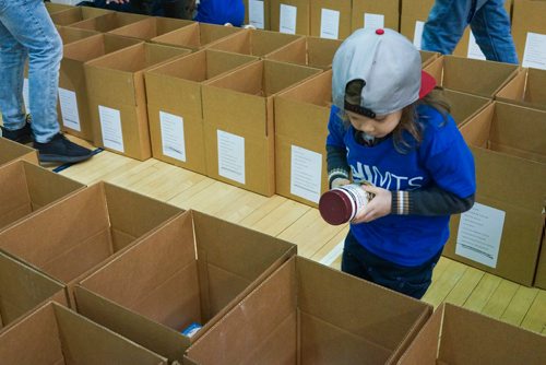 Katie McKenzie / Ma Mawi Wi Chi Itata Centre
One of the volunteers Charlie packs hampers at R. B. Russell School for the 16th annual Christmas Hamper Drive hosted by Ma Mawi Wi Chi Itata Centre and Bell MTS.

181222 - Saturday, December 22, 2018.