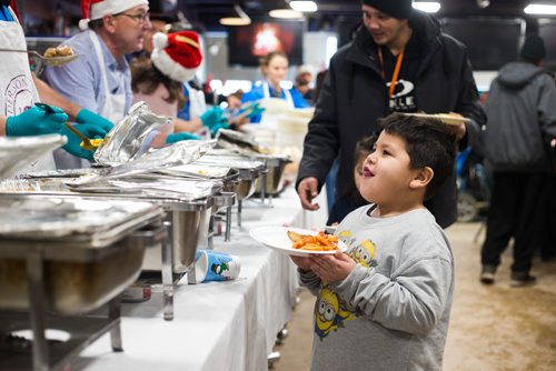MIKAELA MACKENZIE / WINNIPEG FREE PRESS
Devin Thomas, five, is served at the 13th Annual Christmas Eve Feast for new immigrants, international students who cant make it home for the holidays, and people in the inner city at X-Cues Café in Winnipeg on Monday, Dec. 24, 2018. 
Winnipeg Free Press 2018.