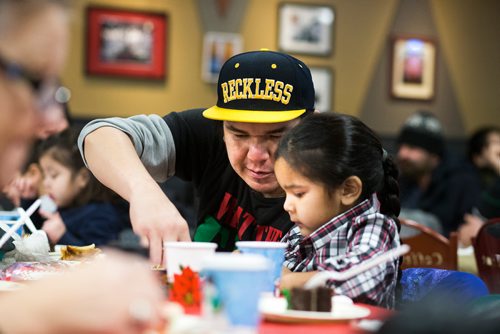 MIKAELA MACKENZIE / WINNIPEG FREE PRESS
Sara Apetagon, five, and her dad, Dustin, eat at the 13th Annual Christmas Eve Feast for new immigrants, international students who cant make it home for the holidays, and people in the inner city at X-Cues Café in Winnipeg on Monday, Dec. 24, 2018. 
Winnipeg Free Press 2018.