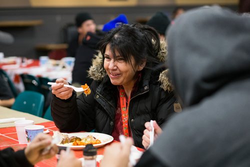 MIKAELA MACKENZIE / WINNIPEG FREE PRESS
Sarah Easter laughs while eating at the 13th Annual Christmas Eve Feast for new immigrants, international students who cant make it home for the holidays, and people in the inner city at X-Cues Café in Winnipeg on Monday, Dec. 24, 2018. 
Winnipeg Free Press 2018.