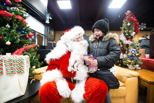 MIKAELA MACKENZIE / WINNIPEG FREE PRESS
Kayleigh Thompson, eight, gives Santa a big smile at the 13th Annual Christmas Eve Feast for new immigrants, international students who cant make it home for the holidays, and people in the inner city at X-Cues Café in Winnipeg on Monday, Dec. 24, 2018. 
Winnipeg Free Press 2018.