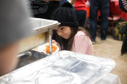 MIKAELA MACKENZIE / WINNIPEG FREE PRESS
Kayleigh Thompson, eight, checks out the serving dishes at the 13th Annual Christmas Eve Feast for new immigrants, international students who cant make it home for the holidays, and people in the inner city at X-Cues Café in Winnipeg on Monday, Dec. 24, 2018. 
Winnipeg Free Press 2018.