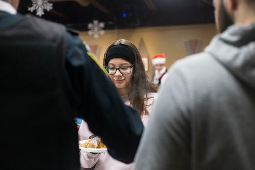 MIKAELA MACKENZIE / WINNIPEG FREE PRESS
Nova Hobson is served a the 13th Annual Christmas Eve Feast for new immigrants, international students who cant make it home for the holidays, and people in the inner city at X-Cues Café in Winnipeg on Monday, Dec. 24, 2018. 
Winnipeg Free Press 2018.