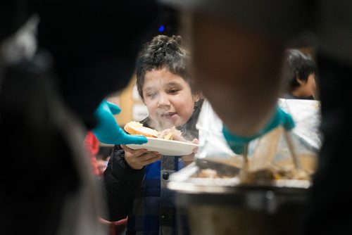 MIKAELA MACKENZIE / WINNIPEG FREE PRESS
Kevin Nabe, nine, is served a the 13th Annual Christmas Eve Feast for new immigrants, international students who cant make it home for the holidays, and people in the inner city at X-Cues Café in Winnipeg on Monday, Dec. 24, 2018. 
Winnipeg Free Press 2018.